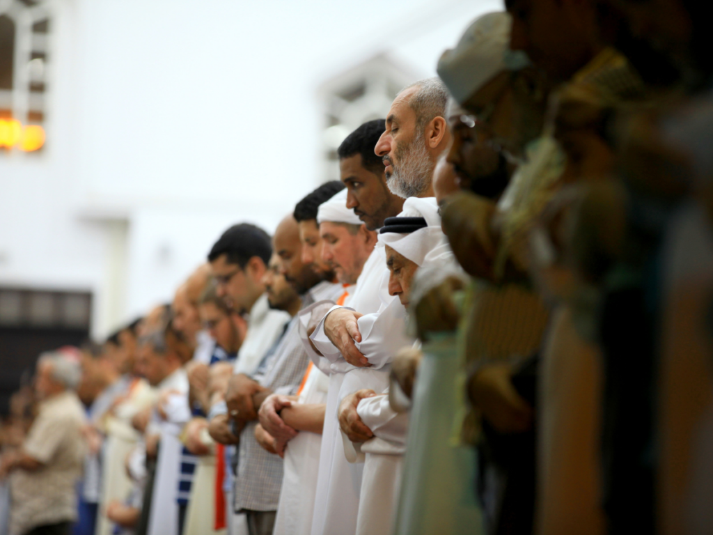 A congregation of Muslim men praying in a Mosque